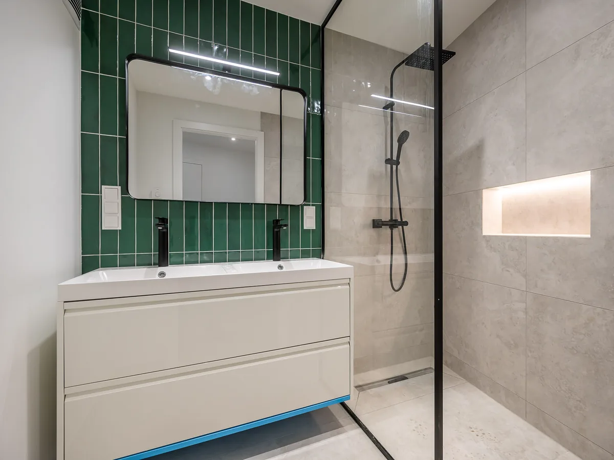 Fertiges Bad mit Walk-in-Dusche und grünen Wandfliesen